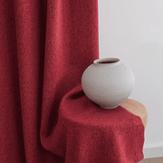 Burgundy linen-look curtains with soft flowing folds draped beside a white ceramic vase