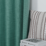 Dusty Teal linen-look curtains beside an upholstered chair in a cozy interior