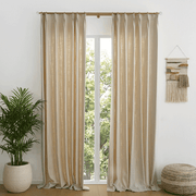 Helen oatmeal linen-look room darkening curtains framing a tall window in a bright living room